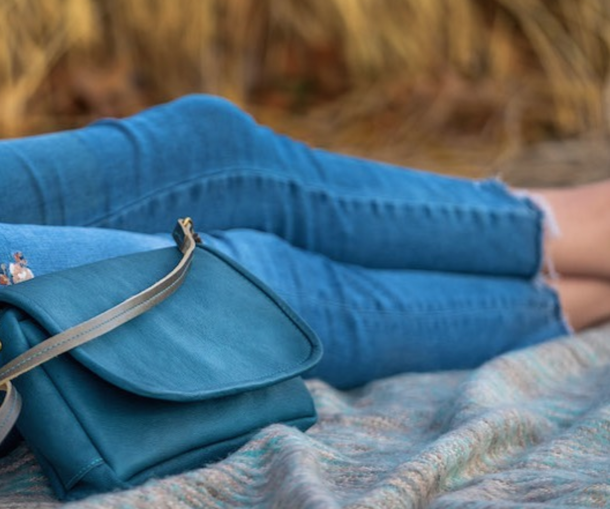 sitting on a blanket next to the crossbody bag